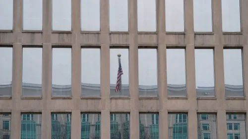 واجهة مبنى مكتب إدارة شؤون الموظفين الفيدرالي، تعكس النوافذ العلم الأمريكي، مما يعكس التوترات الإدارية الحالية.