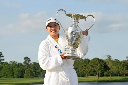 ماو سايجو، لاعبة الغولف اليابانية، تحتفل بفوزها ببطولة شيفرون للغولف، حاملة الكأس في ملعب كارلتون وودز.