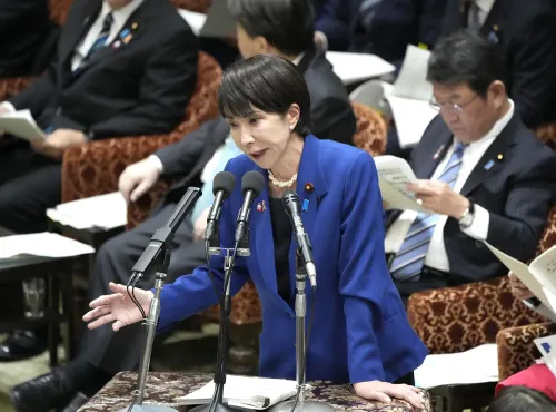 زعيمة يابانية تتحدث في البرلمان، تعبر عن قلقها بشأن التوترات مع الصين وتأثيرها على الأمن القومي، وسط حضور أعضاء آخرين.