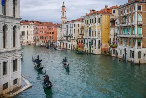 منظر لقناة في مدينة البندقية، مع قوارب الجندول الخشبية والمباني التاريخية الملونة على ضفافها، يبرز جمال المدينة الإيطالية.