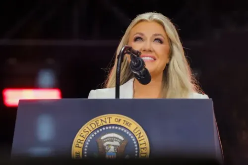 امرأة مبتسمة تتحدث إلى ميكروفون أمام شعار الرئاسة، تعكس أجواء إيجابية خلال حدث سياسي.