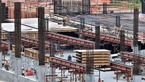 تظهر الصورة مشهدًا لموقع بناء مع عمال يجري العمل على الهياكل، مما يعكس نشاط سوق العمل في ظل تراجع فرص العمل في فبراير.