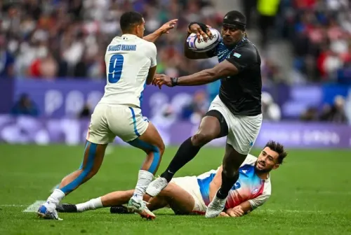 لاعب الرجبي جوسيا رايسوكي يتجاوز مدافعين خلال مباراة في أولمبياد باريس 2024، حيث كان ضمن منتخب فيجي الذي حصل على الميدالية الفضية.