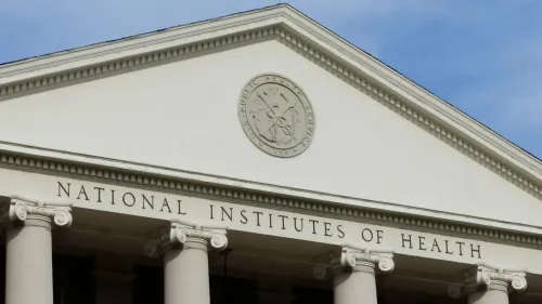 واجهة مبنى المعاهد الوطنية للصحة، مع التركيز على الاسم والشعار، تعكس الجدل حول تخفيضات التمويل لأبحاث الصحة العامة.