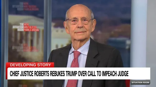 رئيس القضاة جون روبرتس يتحدث في برنامج إخباري، مع خلفية تظهر مبنى حكومي، مع التركيز على قضايا السلطة القضائية.