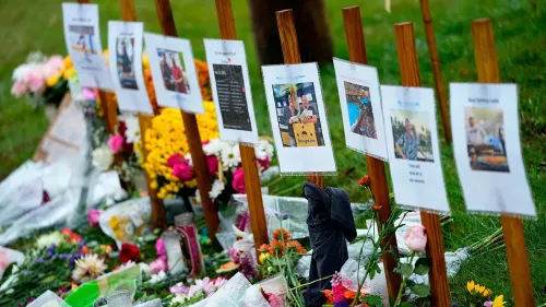 ترتيب لافتات تحمل صورًا وذكريات للأشخاص الذين فقدوا في حادث إطلاق النار في لويستون، محاطة بالزهور والشموع.