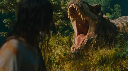 ديناصور تي-rex يفتح فمه في مشهد مثير من فيلم "Jurassic World Rebirth"، مع خلفية طبيعية خضراء وشخصية بشرية في المقدمة.