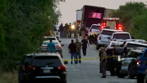 موقع الحادث حيث تم اكتشاف 53 مهاجرًا متوفى في شاحنة في سان أنطونيو، مع وجود الشرطة والإسعاف في مكان الحادث.