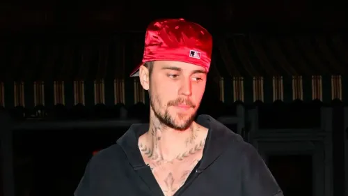 جاستن بيبر يتحدث عن مشاعر عدم الاستحقاق والقلق بشأن صحته، مرتديًا قبعة حمراء في صورة تظهره بتعب واضح.