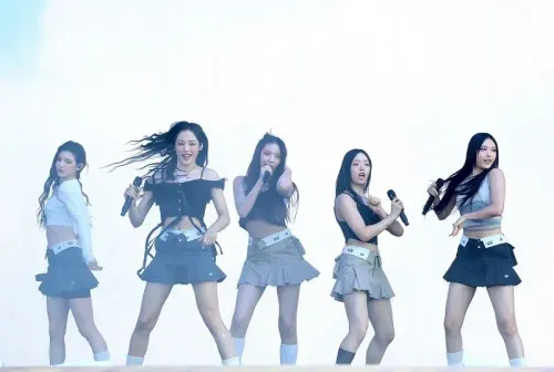 فرقة NJZ تؤدي عرضًا حيًا، حيث يظهر الأعضاء الخمسة بملابس عصرية، مشددين على تحولهم الجديد بعد تغيير الاسم وسط نزاع قانوني.