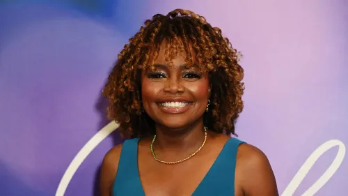 كارين جان بيير تبتسم في حدث، مرتدية فستان أزرق، تعكس تحولها السياسي إلى الاستقلالية وتستعد لإطلاق كتابها الجديد حول السياسة الأمريكية.