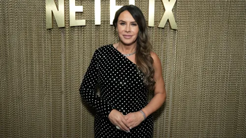 كارلا صوفيا غاسكون ترتدي فستانًا منقطًا باللون الأسود، تقف أمام خلفية تحمل شعار نتفليكس، تعبر عن امتنانها لترشيحها للأوسكار.