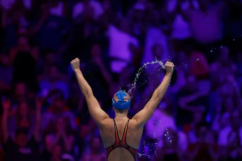 تظهر السباحة كاتي ليديكي وهي تحتفل بفوزها، حيث ترفع ذراعيها في الهواء وسط حشد متحمس، استعدادًا لبطولة العالم للألعاب المائية.