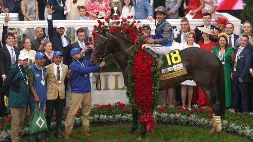 الجواد "سوفرينتي" مع الفائزين في سباق كنتاكي داربي، محاط بالزهور الحمراء، بعد تحقيقه الفوز في السباق.