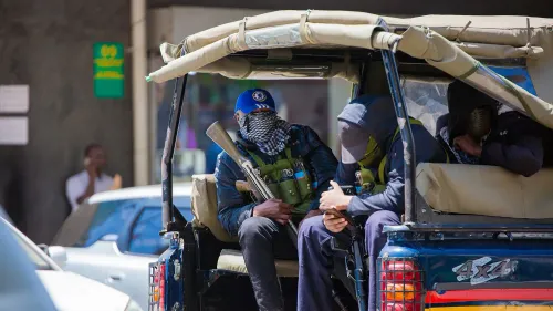 مجموعة من الرجال الملثمين يحملون أسلحة في سيارة، مما يعكس حالة الخوف والترهيب في كينيا وسط عمليات اختطاف الناشطين.