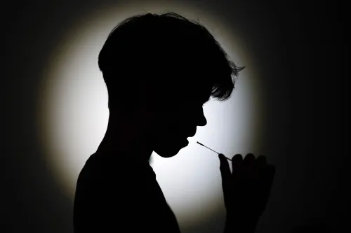 صورة لصبي في الظل يستخدم مسحة طبية، تعكس القلق بشأن متغير كوفيد-19 الجديد "سيكادا" وتأثيره على الأطفال.