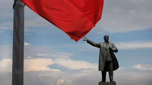 تمثال فلاديمير لينين في أوش، قيرغيزستان، الذي يبلغ ارتفاعه 23 مترًا، مُسقط على الأرض بعد إزالته، مع سارية علم حمراء خلفه.