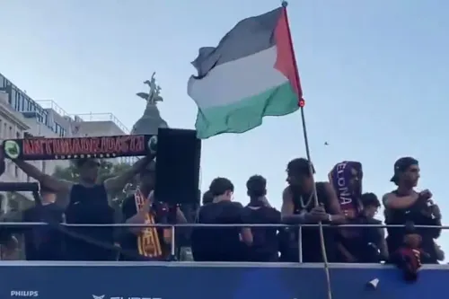 لاعب برشلونة الشاب لامين يامال يرفع العلم الفلسطيني خلال احتفالات الفريق بلقب الدوري الإسباني في شوارع برشلونة.