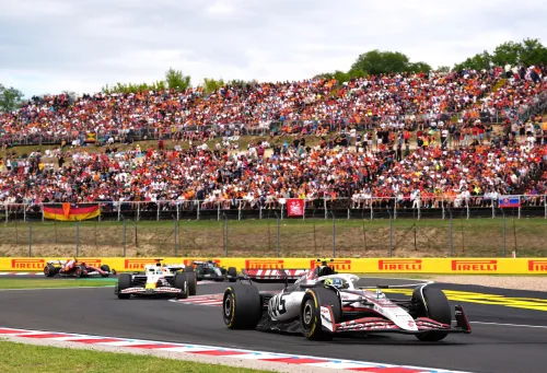 سيارات الفورمولا 1 تتسابق في سباق الجائزة الكبرى المجري، مع جمهور كبير خلفهم، حيث يتنافس لاندو نوريس وأوسكار بياستري.