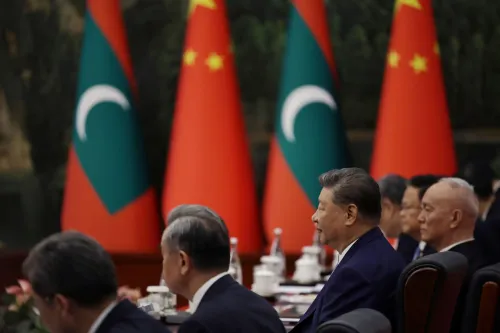 شي جين بينغ يجلس في اجتماع مع قادة دوليين، خلفه أعلام الصين وجزر المالديف، في سياق قمة لتعزيز الشراكات العالمية.