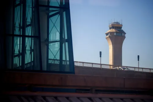 تظهر الصورة برج مراقبة الحركة الجوية في مطار، مع خلفية زجاجية حديثة. تعكس الأوضاع الحالية نقص الموظفين وتأثير الإغلاق الحكومي على سلامة السفر الجوي.