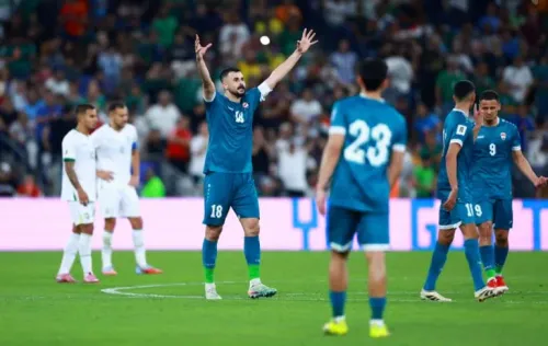 أيمن حسين، مهاجم المنتخب العراقي، يحتفل بعد تسجيل هدف في مباراة كأس العالم، محاطًا بزملائه في الفريق، مع جمهور متحمس في الخلفية.