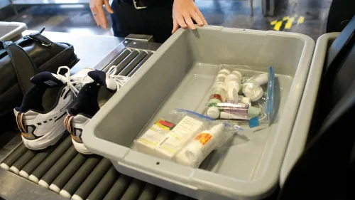 حذاء رياضي موضوع بجانب سلة تفتيش تحتوي على زجاجات صغيرة من السوائل والأدوية، في سياق مناقشة حول قواعد الأمن في المطارات.