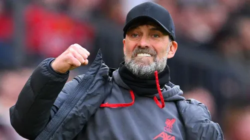 يورغن كلوب مدرب ليفربول يحتفل بحماس خلال مباراة في الدوري الإنجليزي الممتاز، مع شعار النادي واضح على سترته.