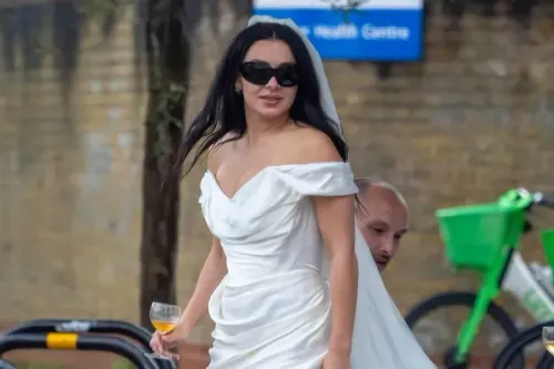 تشارلي إكس سي إكس ترتدي فستان زفاف قصير من فيفيان ويستوود مع نظارات شمسية، تحتسي النبيذ في أجواء غير تقليدية في شرق لندن.