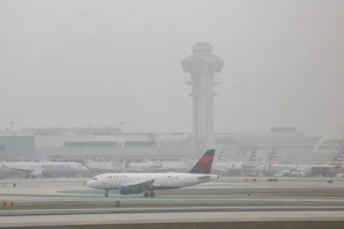 مطار لوس أنجلوس الدولي (LAX) يظهر فيه طائرة تابعة لشركة دلتا، مع أبراج المراقبة والطائرات الأخرى في الخلفية، في سياق تحقيقات تتعلق بتهم تهريب أسلحة.