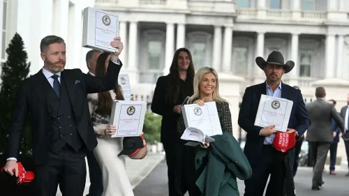 مجموعة من الشخصيات الإعلامية المؤيدة لترامب تحمل مجلدات مكتوب عليها "ملفات إبشتاين: المرحلة 1" خارج البيت الأبيض، وسط أجواء من التوتر والترقب.