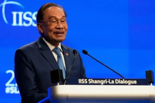 أنور إبراهيم يتحدث في مؤتمر، حيث أعلن عن حزمة إجراءات لتخفيف تكاليف المعيشة في ماليزيا، بما في ذلك دعم نقدي للمواطنين.