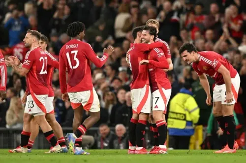 لاعبو مانشستر يونايتد يحتفلون بعد تحقيق الفوز في مباراة نصف النهائي، مع التركيز على الأجواء الإيجابية قبل نهائي الدوري الأوروبي.