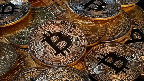 عملات البيتكوين المعدنية تتراص فوق بعضها، مع تفاصيل دقيقة على السطح، تمثل الأصول الرقمية التي ستخضع لمتطلبات الإبلاغ الضريبي.