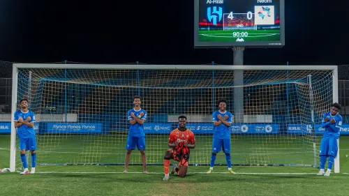 لاعبو شباب الهلال يحتفلون أمام المرمى بنتيجة 4-0 ضد NEOM في دوري Joy Elite للشباب بالرياض، مع لوحة النتيجة في الخلفية.