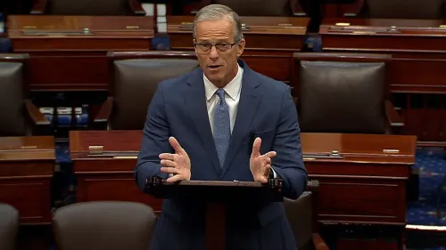 زعيم الأغلبية في مجلس الشيوخ جون ثون يتحدث في قاعة التصويت حول مشروع قانون ترامب، مع مقاعد فارغة خلفه، خلال جلسة تصويت ماراثونية.