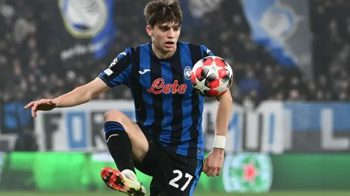 ماركو بالستيرا لاعب كرة قدم إيطالي شاب يرتدي قميص أتالانتا الأزرق والأسود يتحكم بالكرة خلال مباراة في دوري أبطال أوروبا.
