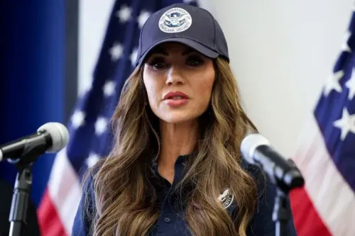 وزيرة الأمن الداخلي كريستي نويم تتحدث خلال مؤتمر صحفي في لوس أنجلوس، مع أعلام الولايات المتحدة خلفها، مؤكدة على استمرار الحملة ضد المهاجرين.