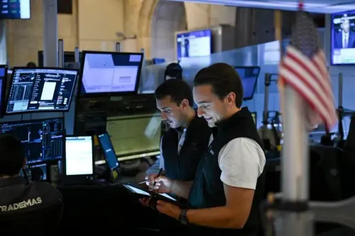 متداولون في سوق الأسهم يتابعون الشاشات ويحللون البيانات المالية في بيئة نشطة، مع وجود علم أمريكي في الخلفية.