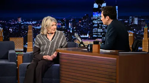 مارثا ستيوارت تتحدث مع جيمي فالون في برنامجه "ذا تونايت شو"، مع خلفية مميزة لمدينة نيويورك ليلاً، تعكس أجواء العرض.