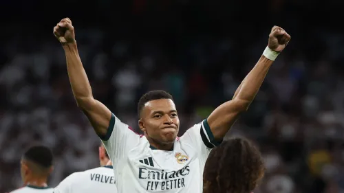 كيليان مبابي لاعب ريال مدريد يرفع يديه احتفالاً في مباراة قبل مواجهة رايو فاليكانو، مع التركيز على دوره كمهاجم بارز.