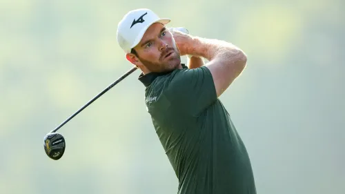 لاعب غولف محترف في ملعب دبي ديزرت كلاسيك، يركز على تسديد الكرة بمضربه، مما يعكس أهمية الصحة النفسية في الرياضة.