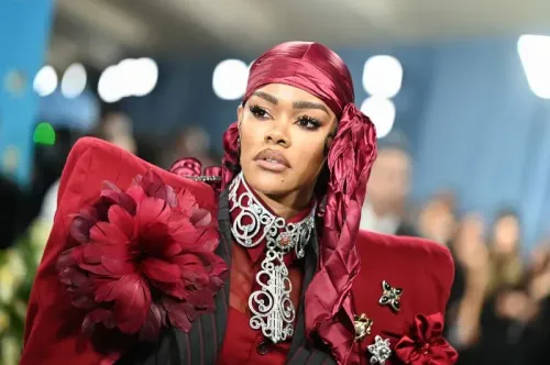 تظهر الصورة نجمة ترتدي فستانًا جريئًا باللون الأحمر مع تفاصيل مزخرفة، خلال حفل الميت غالا في متحف المتروبوليتان.