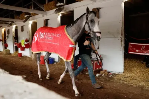 حصان يرتدي غطاءً يحمل شعار ديربي كنتاكي، يسير برفقة مدربه في إسطبل، استعدادًا للمشاركة في السباق الشهير.