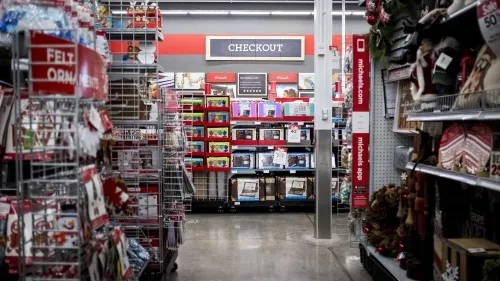 ممر داخل متجر مايكلز يظهر منطقة الدفع مع رفوف مليئة بمنتجات الحرف والاحتفالات، مما يعكس توسع الشركة في لوازم الحفلات.