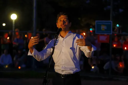 رئيس بلدية مينيابوليس جاكوب فراي يتحدث في تجمع حاشد ليلاً، محاطاً بأشخاص يحملون شموعاً، تنديداً بالعنف المسلح ودعماً للضحايا.