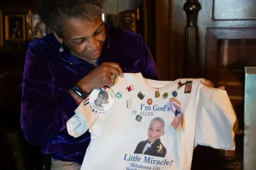 امرأة تحمل قميصًا يحمل صورة بي جيه آلن، الطفل الناجي من تفجير أوكلاهوما سيتي، محاطة بشعارات وذكريات تكريمية.