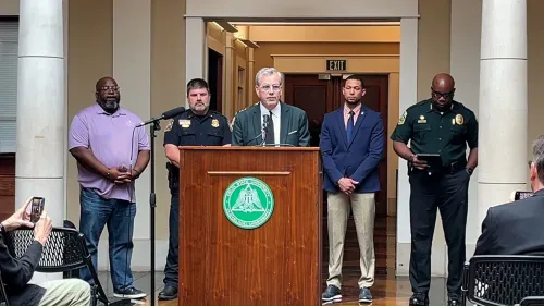 مؤتمر صحفي يتحدث فيه مسؤولون عن وفاة الطالب ديمارترافيون ريد بجامعة دلتا ستيت، مع وجود أفراد من الشرطة والجمهور خلفهم.