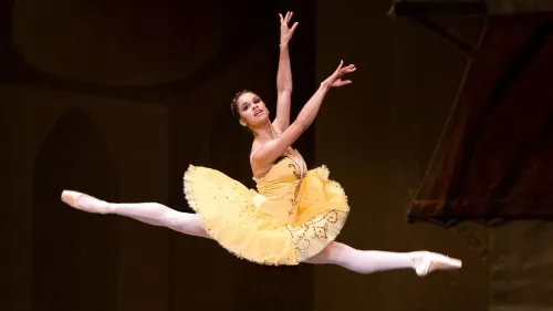 راقصة الباليه ميستي كوبلاند تؤدي قفزة رائعة في فستان أصفر، تعكس شغفها وإبداعها في فن الباليه، وتكريم مسيرتها المهنية.