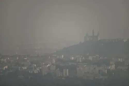 صورة لمدينة مغطاة بالضباب، مع معالم معمارية واضحة في الخلفية، تعكس تأثير التغير المناخي على جودة الهواء.